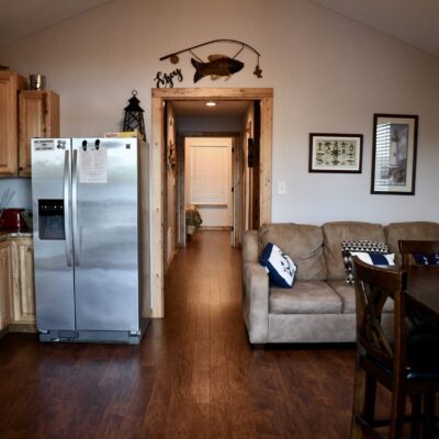 A Living Room Filled With Furniture And A Refrigerator In A Kitchen